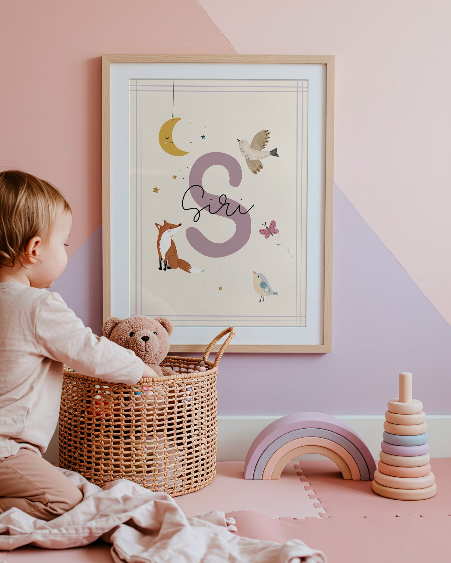 Personalized name poster displayed in a modern nursery, featuring a decorative initial and whimsical children's illustrations.