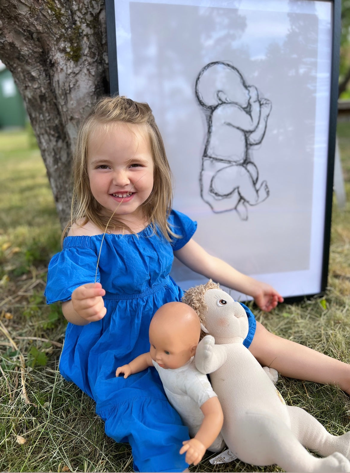 Girl sitting in front of her personalized birth poster in the nursery.