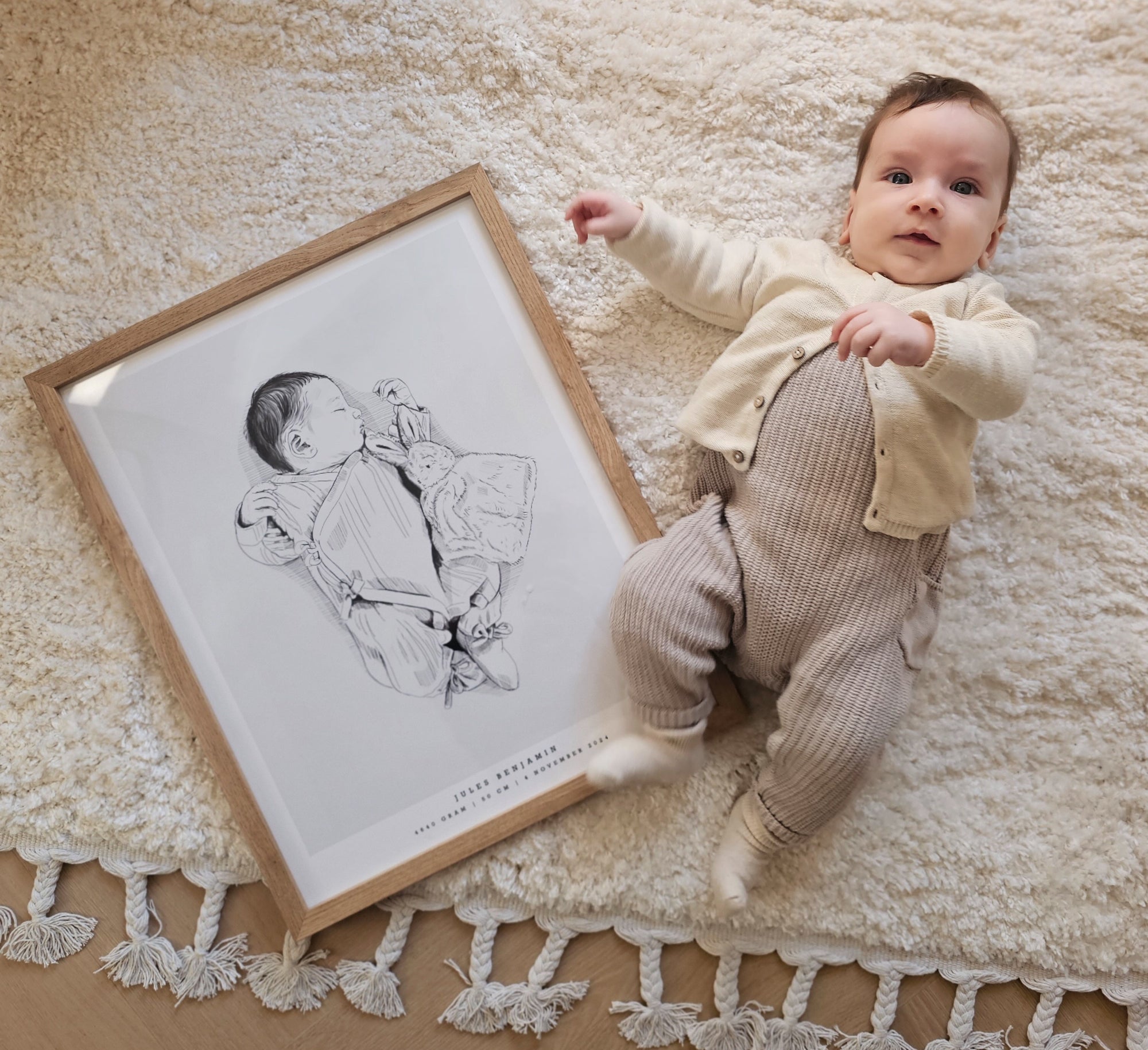 Newborn baby lying next to their personalized hand-drawn birth poster.