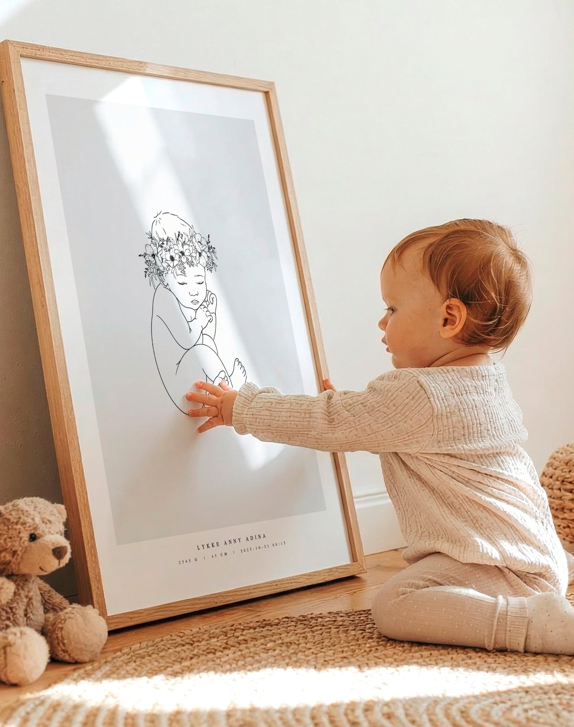Toddler sitting next to their personalized birth poster in the nursery.
